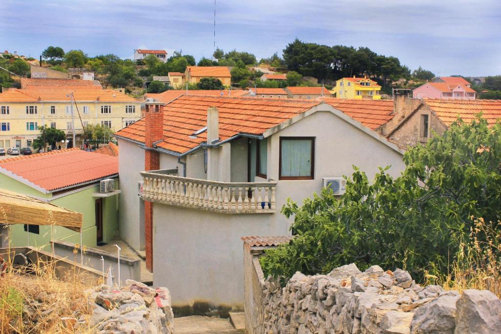 una casa blanca con techos rojos en una ciudad en Apartments by the sea Sali, Dugi otok - 8193 en Sali