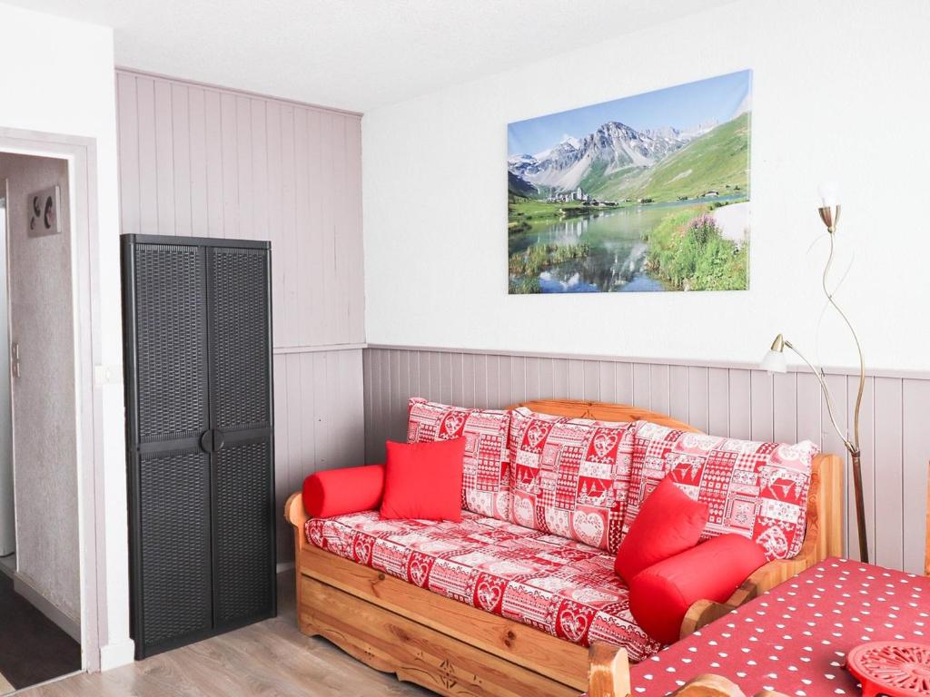 - un salon avec un canapé et des oreillers rouges dans l'établissement Appartement lumineux - Accès direct aux pistes - Balcon - Sud - Animaux acceptés - FR-1-502-411, à Tignes