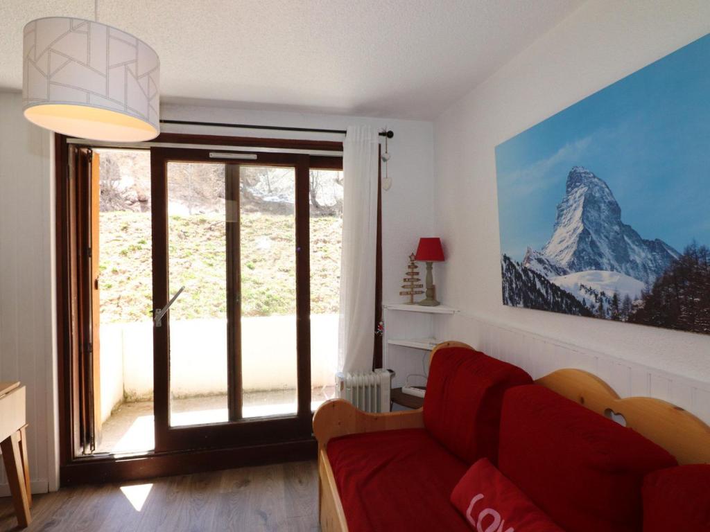 uma sala de estar com um sofá vermelho e uma grande janela em Studio Tignes, 1 pièce, 5 personnes - FR-1-502-415 em Tignes