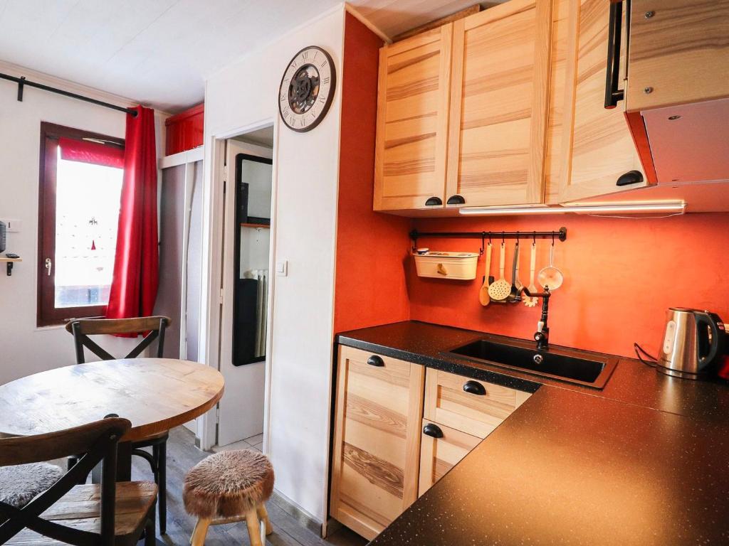 a kitchen with wooden cabinets and a table in it at Studio Tignes, 1 pièce, 2 personnes - FR-1-502-439 in Tignes