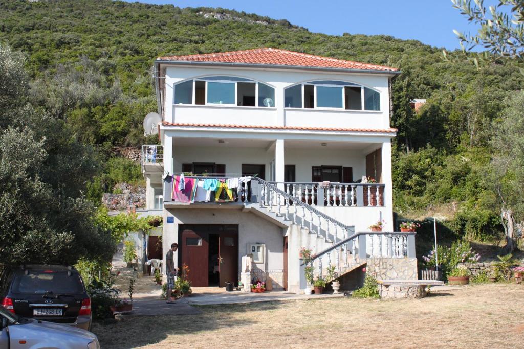 a house with clothes hanging on a balcony at Apartments by the sea Luka, Dugi otok - 8182 in Luka