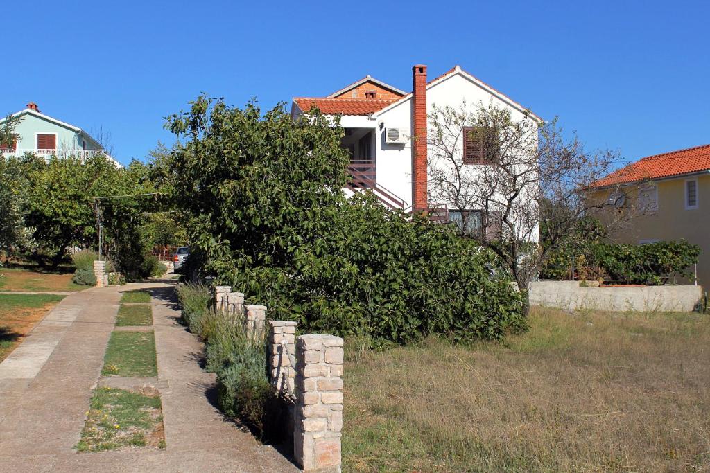 a fence in front of a house with a tree at Apartment Kraj 8372b in Tkon