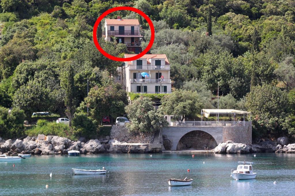 une maison sur une colline avec des bateaux dans l'eau dans l'établissement Apartments by the sea Molunat, Dubrovnik - 8550, à Molunat