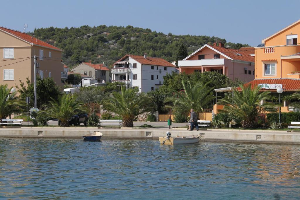 una persona en un bote de remos en un cuerpo de agua en Apartments by the sea Kukljica, Ugljan - 8402, en Kukljica