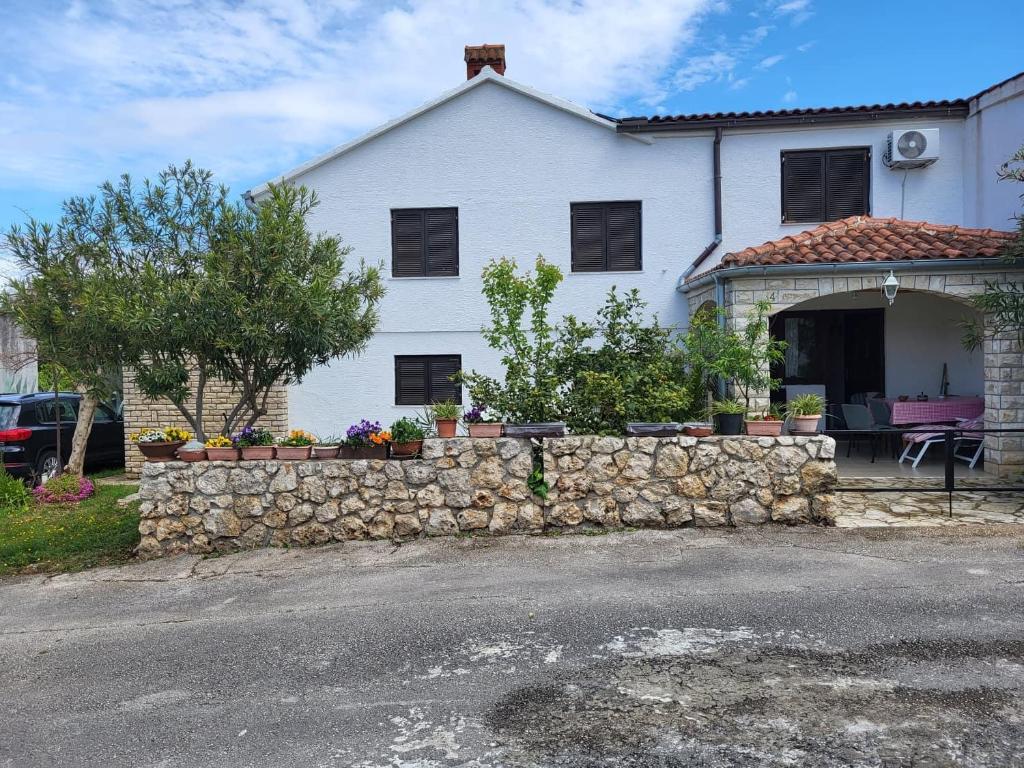 a white house with a stone wall at Apartments with a parking space Zdrelac, Pasman - 8514 in Ždrelac