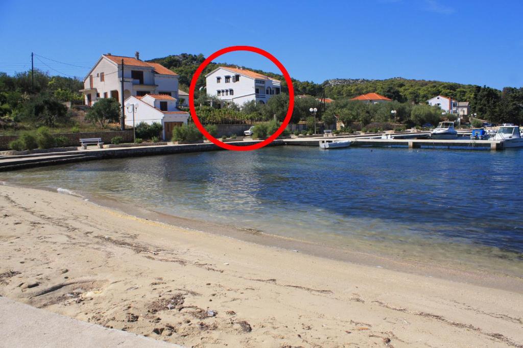 a red circle on a beach next to the water at Apartment Lukoran 8397b in Lukoran