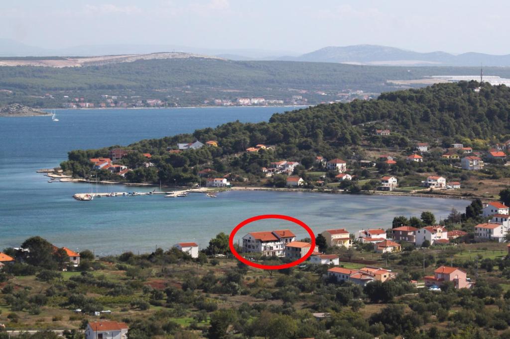 a red house in the middle of a body of water at Apartments and rooms by the sea Mrljane, Pasman - 8464 in Neviđane