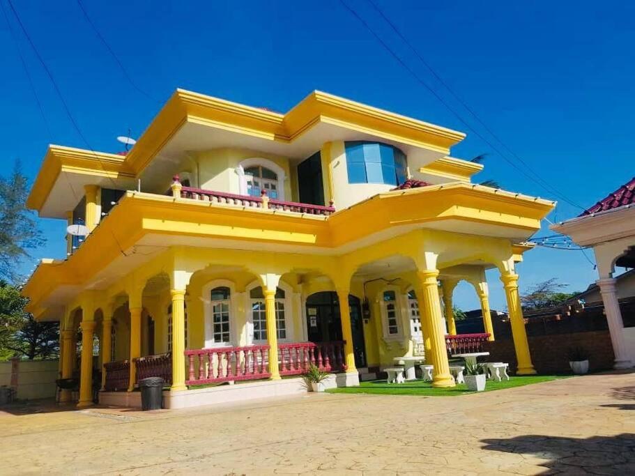 Una casa amarilla con balcón en la parte superior. en Irama Banglo with Private Pool, en Bachok