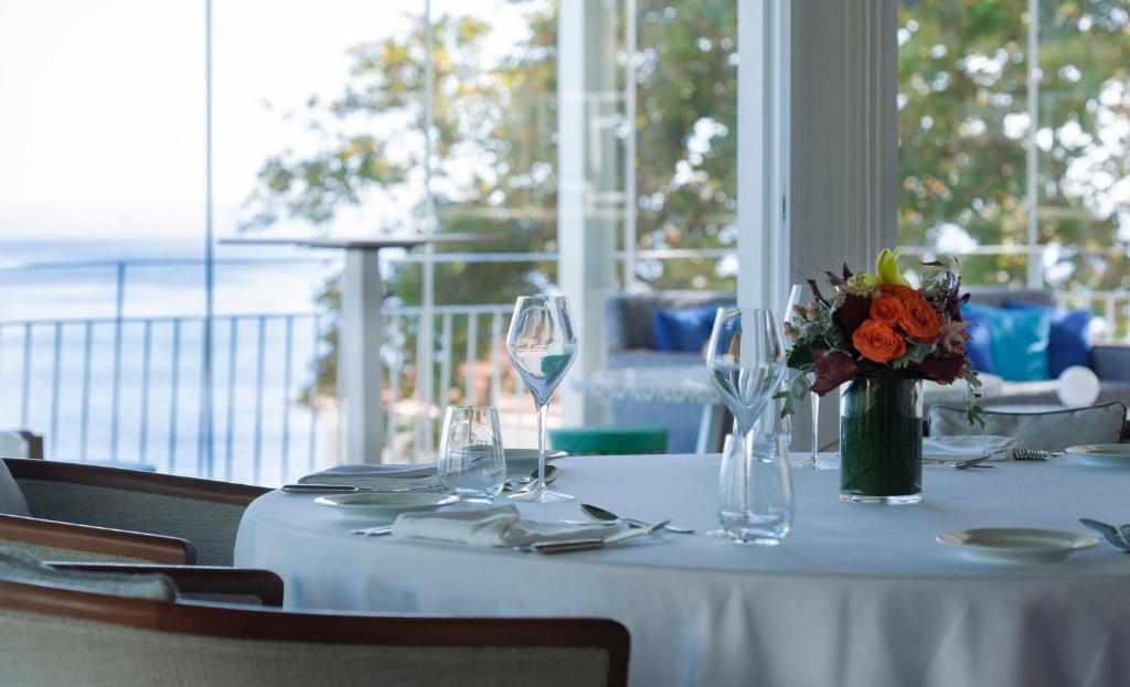 a white table with a vase of flowers and wine glasses at InterContinental Cascais-Estoril by IHG in Estoril