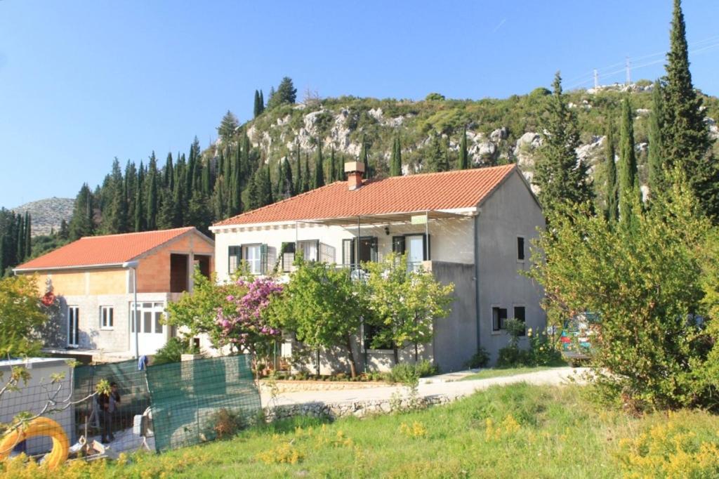 a house with a mountain in the background at Apartments with a parking space Slano, Dubrovnik - 8547 in Slano