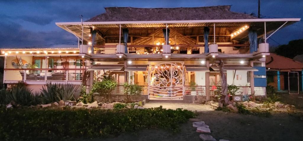 a house with a lit up facade at night at Sirena Surf Lodge Miramar Nicaragua in Miramar