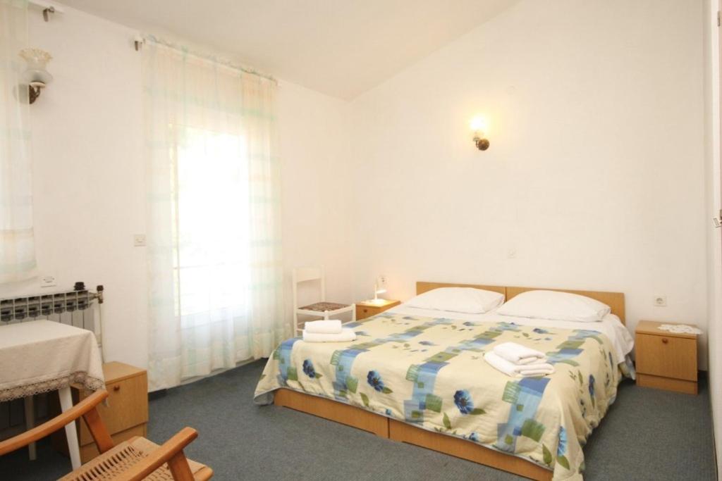 biała sypialnia z łóżkiem i oknem w obiekcie Apartments and rooms by the sea Kukljica, Ugljan - 8408 w mieście Kukljica