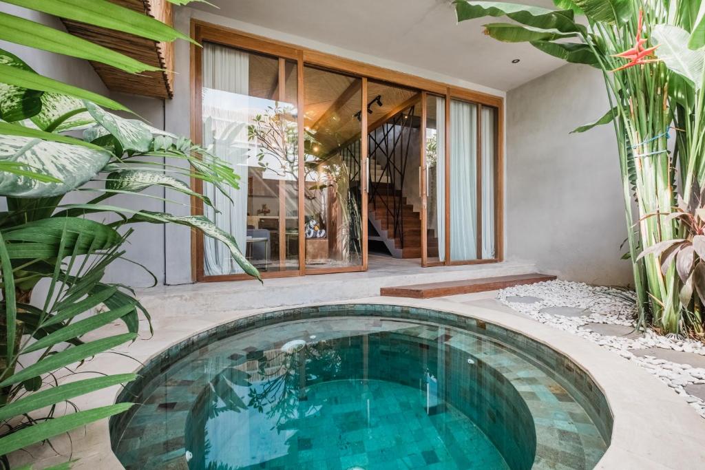 ein Schwimmbad in der Mitte eines Hauses in der Unterkunft Zazen 2 Villa by Hombali in Canggu