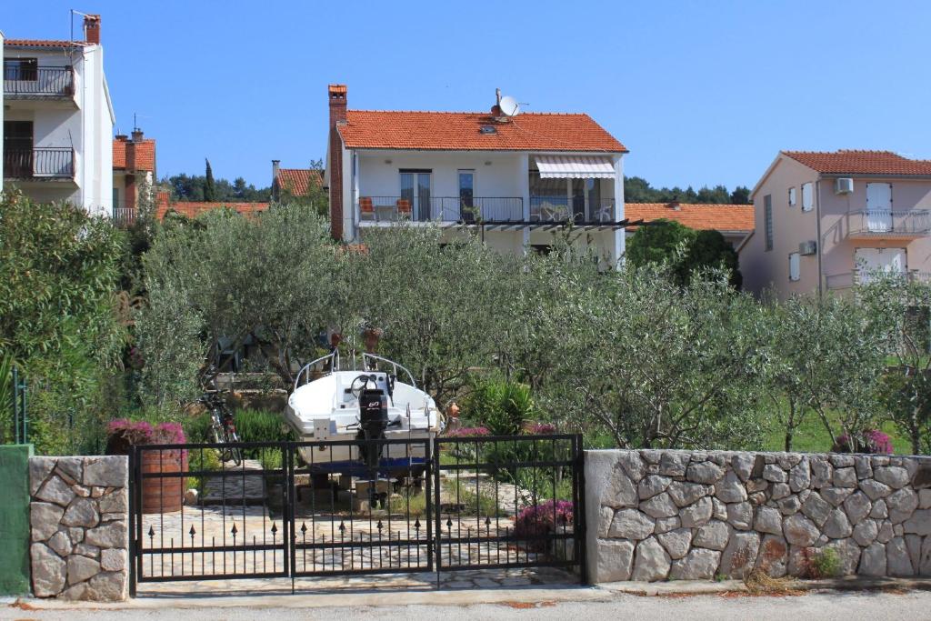 einen Zaun vor einem Haus mit einem Boot in der Unterkunft Apartments with a parking space Stari Grad, Hvar - 8708 in Stari Grad