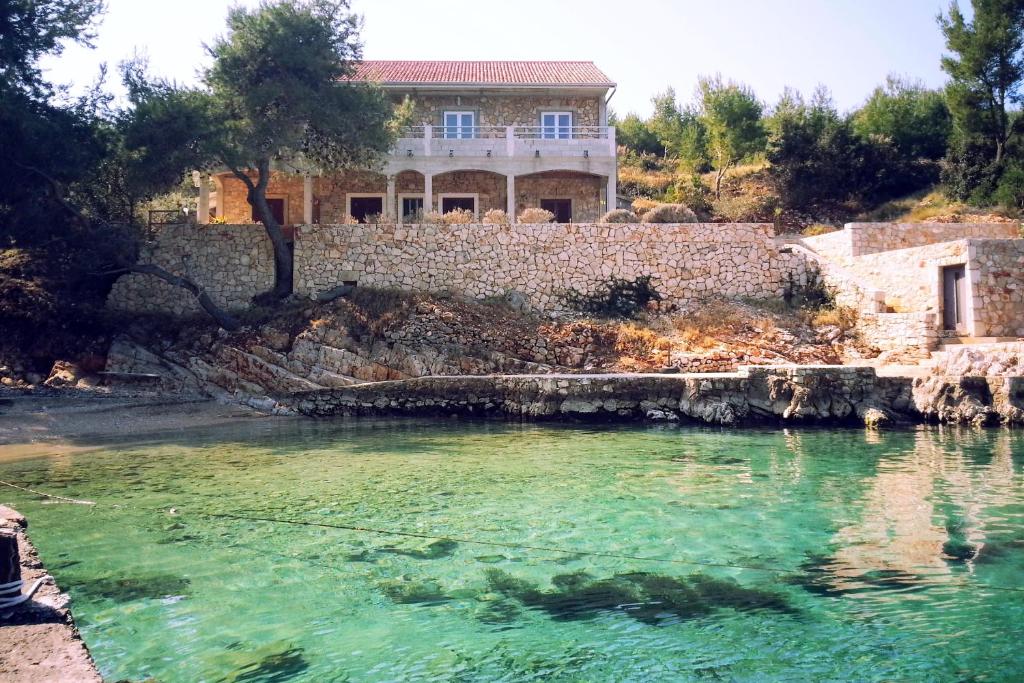 a house sitting on top of a body of water at Apartment Zastupac 8761c in Hvar
