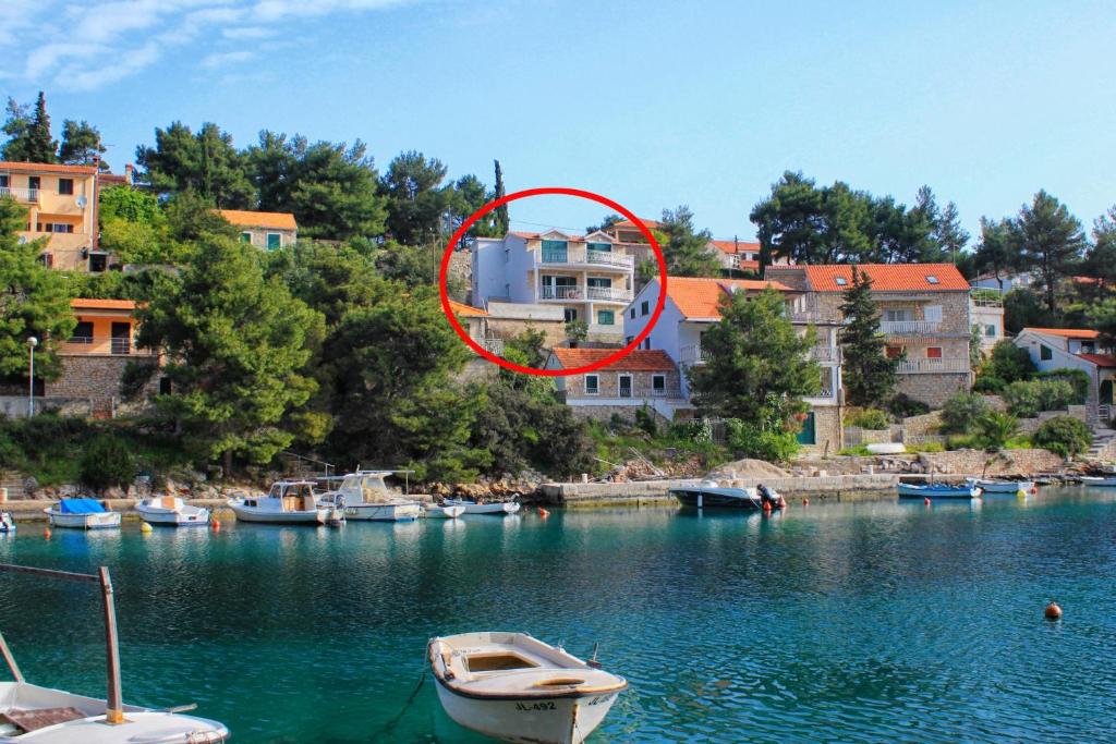 a house in the middle of a body of water with boats at Apartments by the sea Basina, Hvar - 8754 in Vrbanj