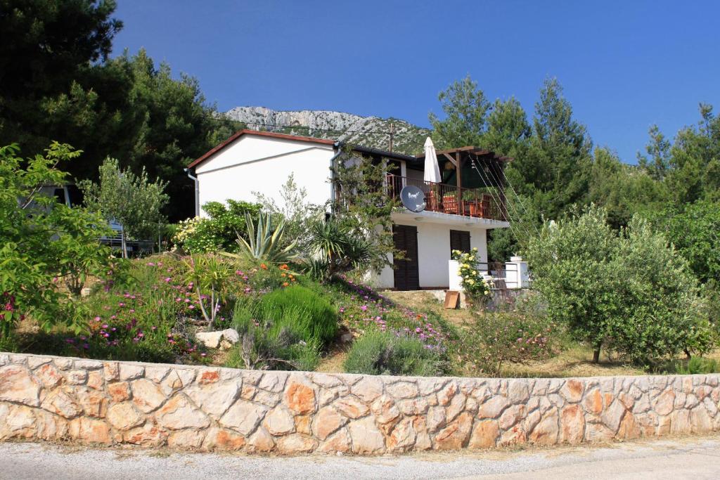 a house on a hill with a stone wall at Apartments with a parking space Zavala, Hvar - 8706 in Jelsa