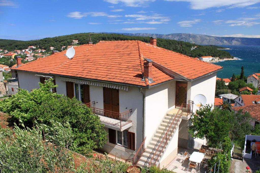 a white house with an orange roof at Apartments and rooms with parking space Jelsa, Hvar - 8798 in Jelsa