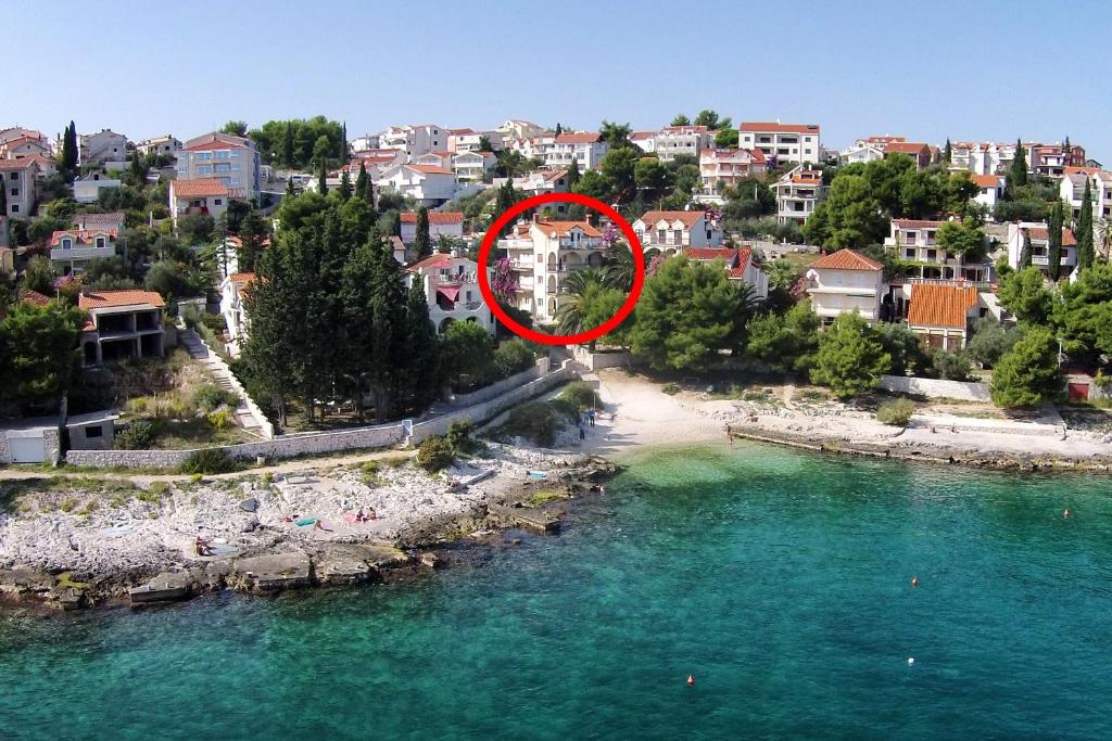 uma vista aérea de uma praia com um círculo vermelho em Rooms by the sea Mavarstica, Ciovo - 10335 em Trogir