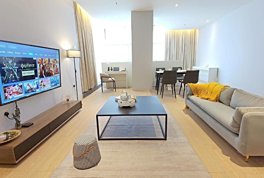 een woonkamer met een bank, een tv en een tafel bij The Vogue @ Bangsar South Mid Valley in Kuala Lumpur