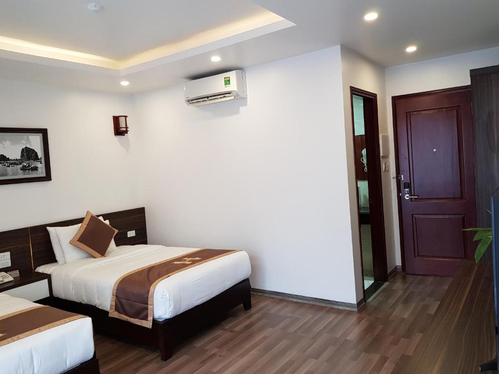 Postel nebo postele na pokoji v ubytování Helen Halong Hotel