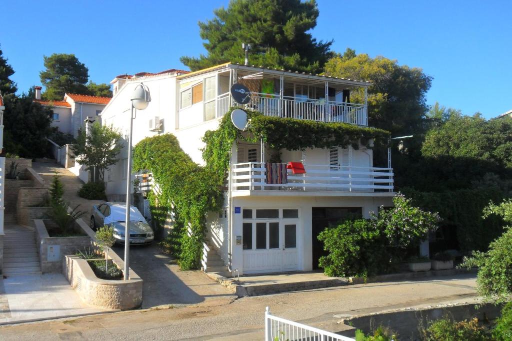 a white house with a porch and a balcony at Seaside holiday house Brna, Korcula - 11038 in Smokvica