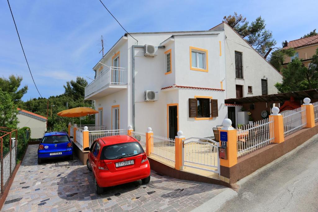 ein rotes Auto, das vor einem Haus parkt in der Unterkunft Apartments by the sea Slatine, Ciovo - 10368 in Trogir