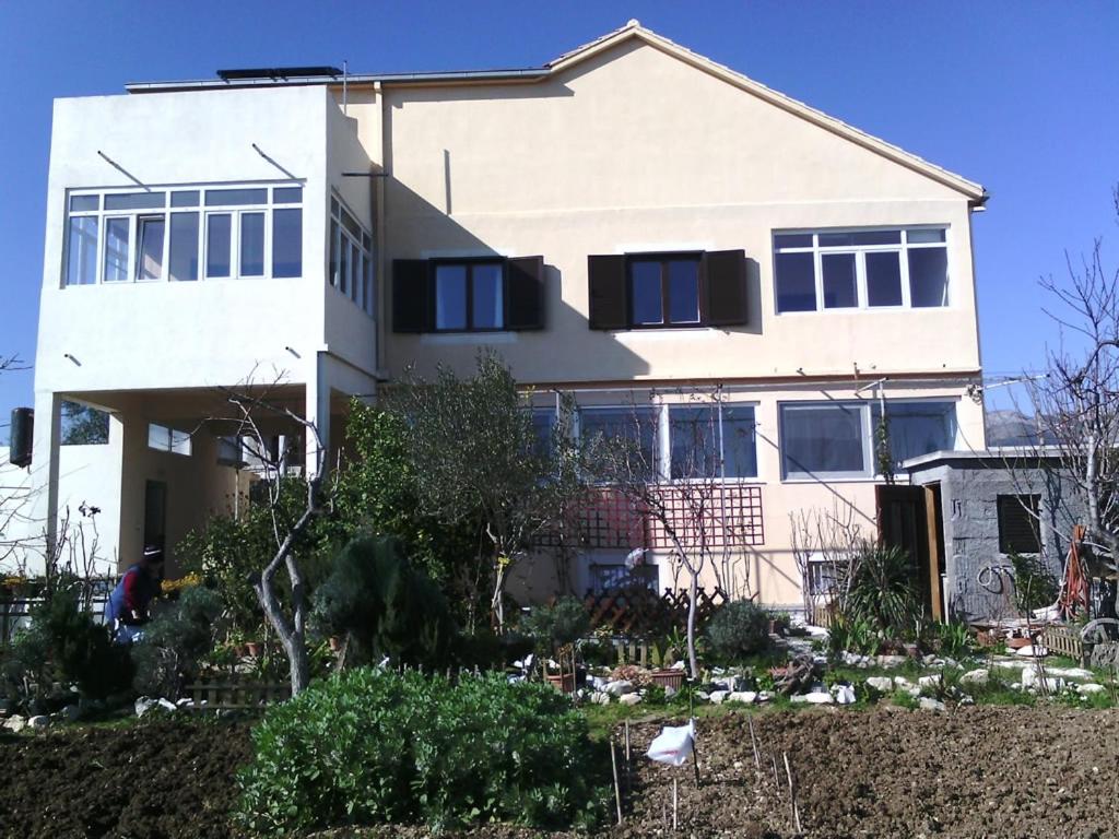 biały dom z czarnymi oknami i krzakami w obiekcie Apartments with a parking space Kastel Stafilic, Kastela - 11022 w mieście Kaštela