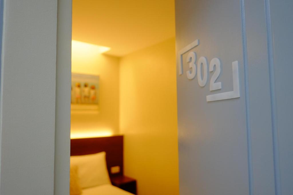 a room with a bed and a clock on the wall at Hotel Simone Kalibo in Kalibo