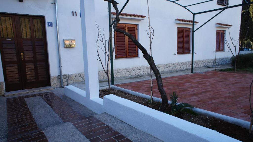 a white house with a door and a brick walkway at Apartments with a parking space Biograd na Moru, Biograd - 11150 in Biograd na Moru