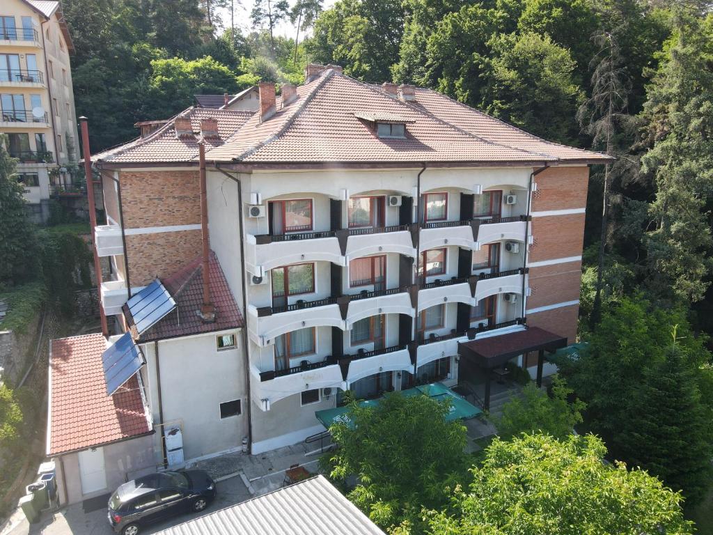 een appartementencomplex met een auto ervoor geparkeerd bij Hotel Panoramic in Râmnicu Vâlcea