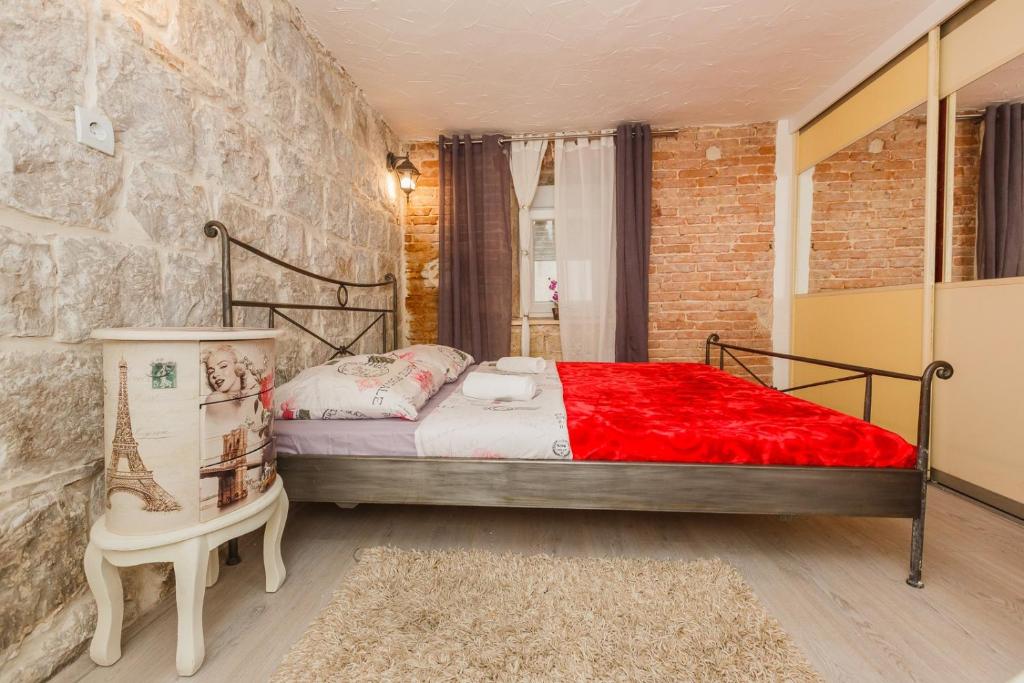 um quarto com uma cama e uma parede de tijolos em Seaside holiday house Kastel Stafilic, Kastela - 11165 em Kaštela