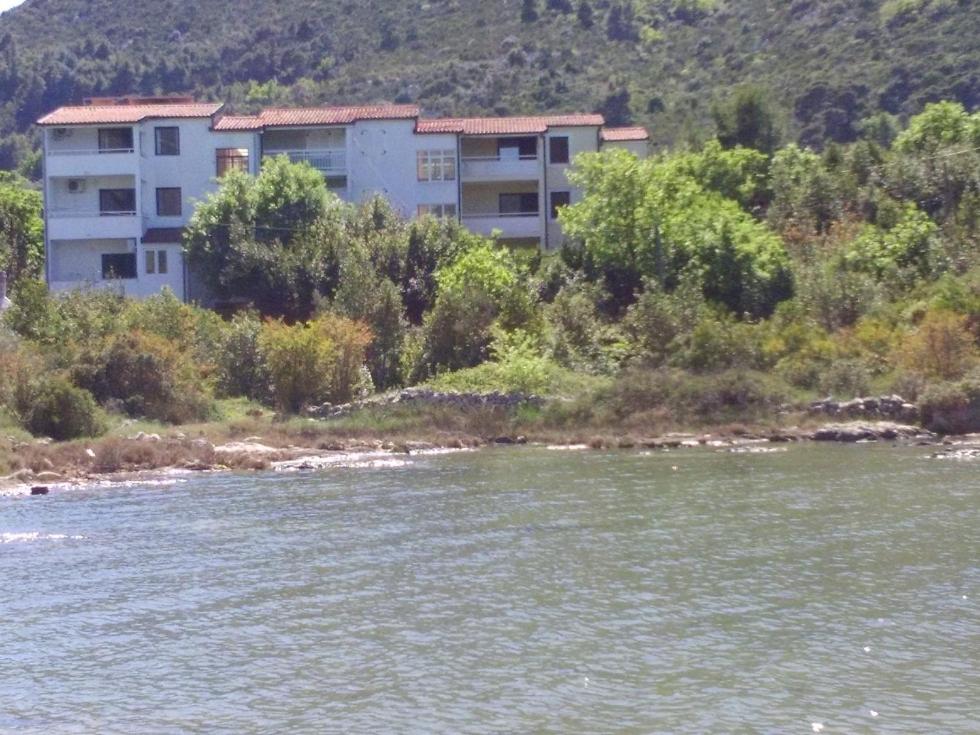 a building on the side of a river at Apartments by the sea Hodilje, Peljesac - 11189 in Ston