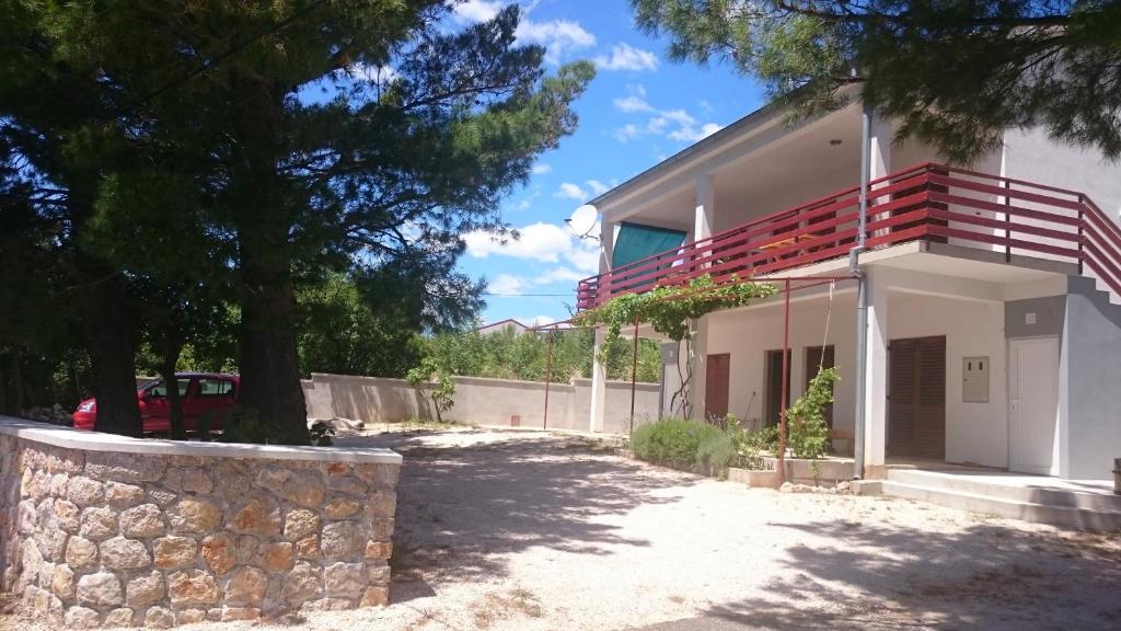 a white house with a stone wall and trees at Apartment Seline 11197b in Starigrad