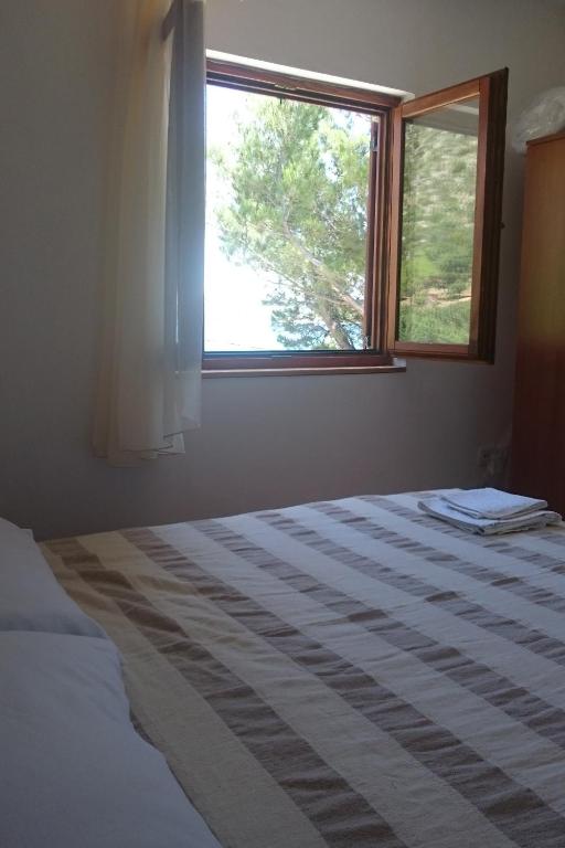 a bedroom with a bed and a window at Apartment Seline 11197b in Starigrad