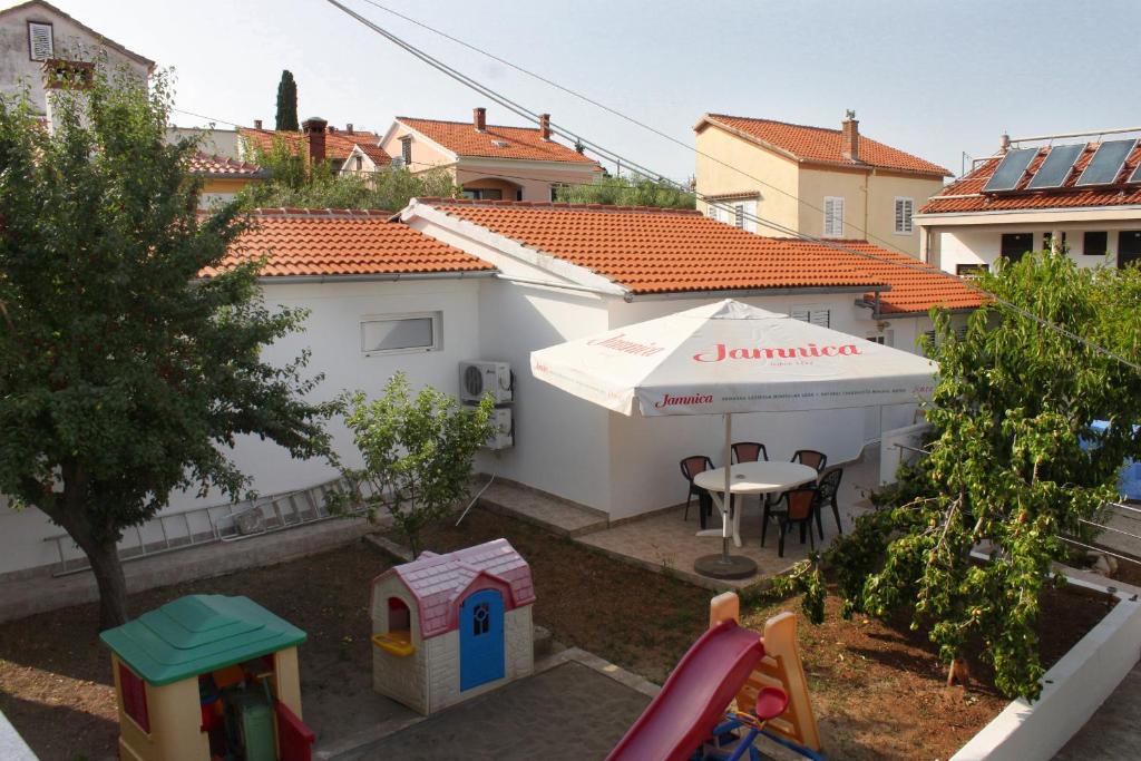 einen Hinterhof mit einem Zelt, einem Tisch und Stühlen in der Unterkunft Family friendly seaside apartments Preko, Ugljan - 8232 in Poljana