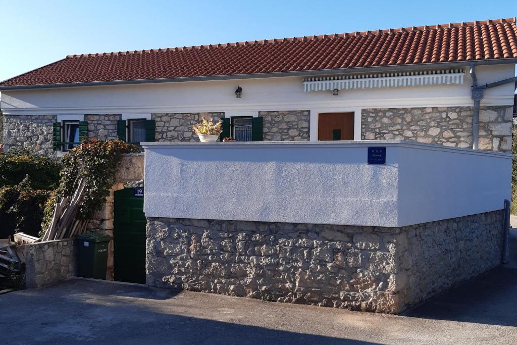 eine Steinmauer vor einem Haus in der Unterkunft Apartments with a parking space Lukoran (Ugljan) - 11203 in Lukoran