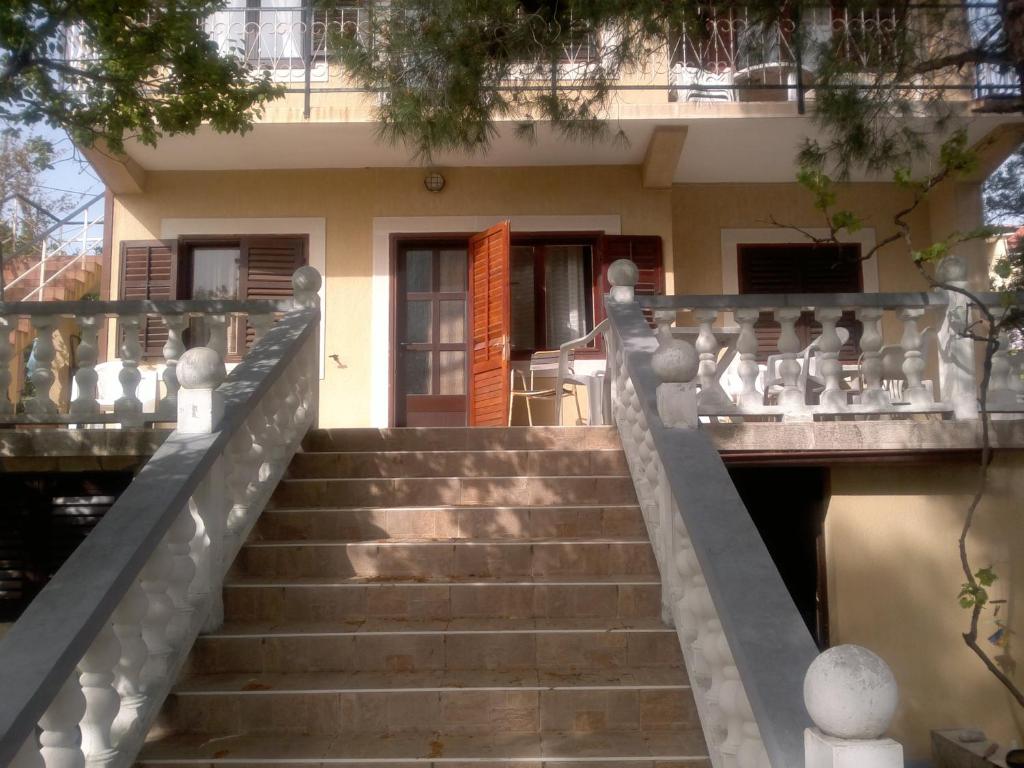 Apartments by the sea Martinscica, Cres - 11279 في مارتينيسكا: درج يؤدي الى منزل مع مبنى