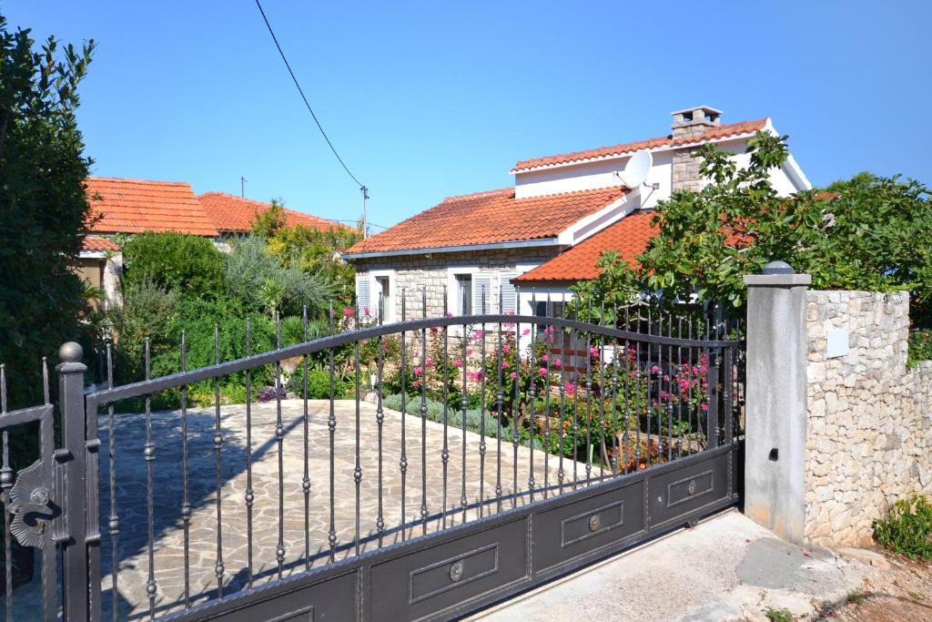 a black iron gate in front of a house at Apartments by the sea Splitska, Brac - 11300 in Splitska