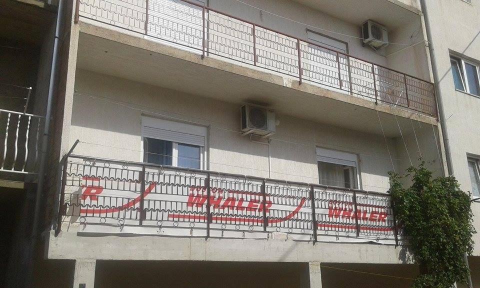 a building with a balcony with a sign on it at Apartments with a parking space Stanici, Omis - 11376 in Čelina