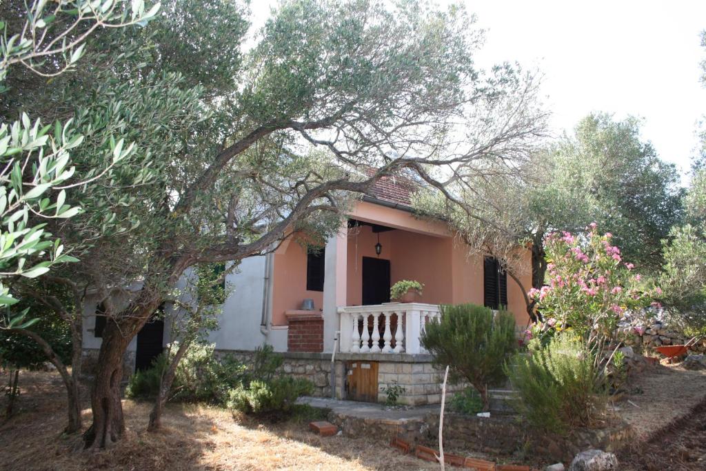 a small house with a porch and trees at Secluded fisherman's cottage Cove Nevidjansko Polje, Pasman - 11392 in Neviđane