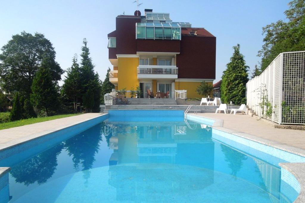 a house with a swimming pool in front of a building at Apartments with a swimming pool Zagreb - 11408 in Zagreb