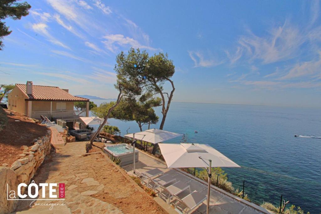 Una casa con sombrillas y vistas al océano en A couper le souffle Magnifique Villa sur l'eau, en La Redonne