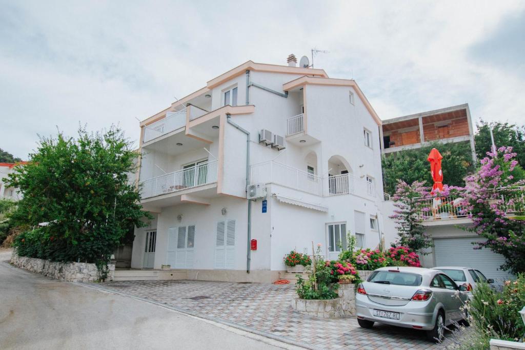 una casa blanca con un coche aparcado delante de ella en Apartments with a parking space Mastrinka, Ciovo - 11283 en Trogir