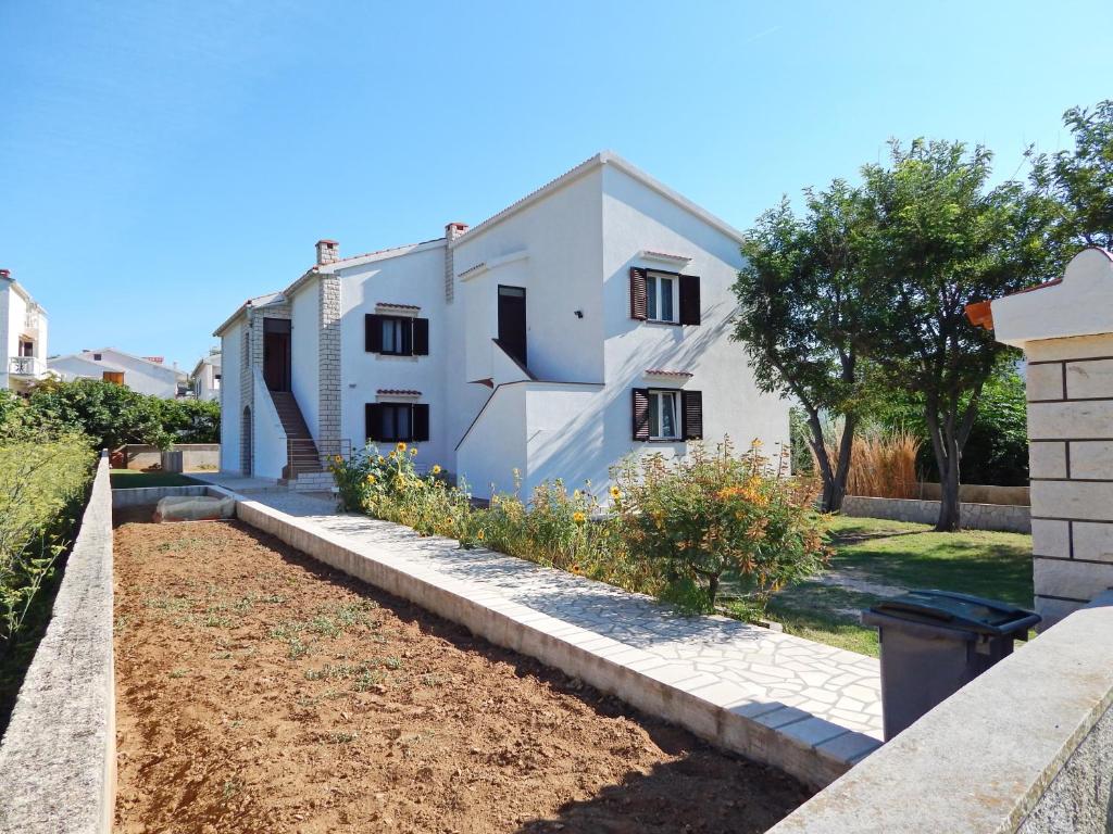 a house with a garden in front of it at Apartments with a parking space Pag - 11358 in Pag