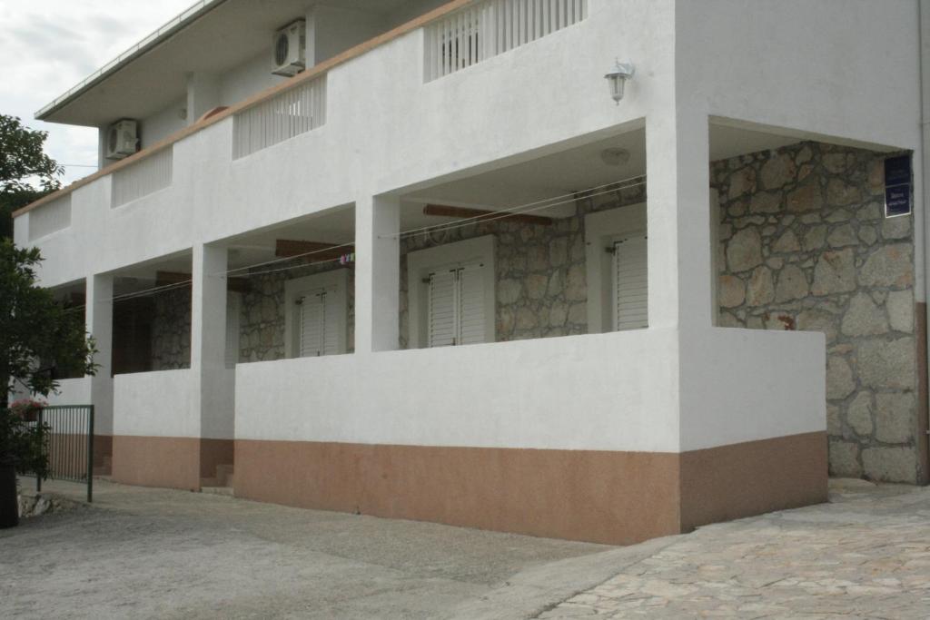a white building with a stone wall at Apartment Gradac 11332a in Gradac