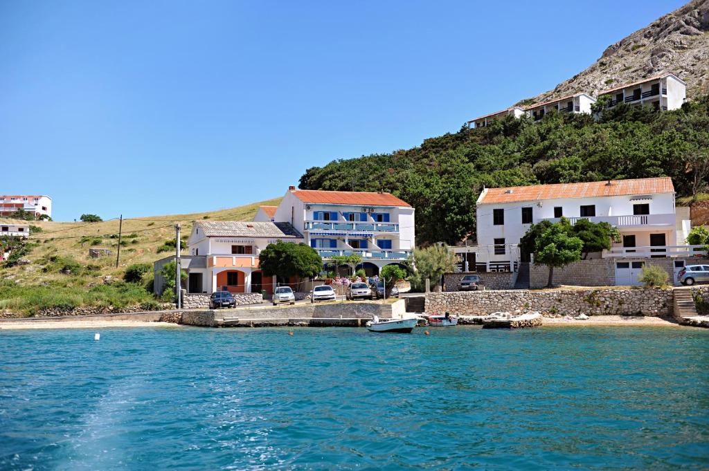 a group of houses on the shore of a body of water at Apartments by the sea Metajna, Pag - 10405 in Zubovići