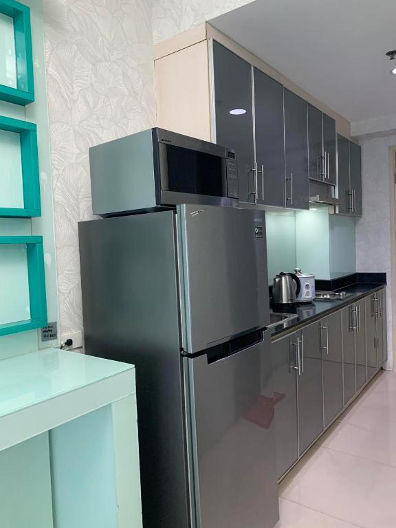 a kitchen with a stainless steel refrigerator and cabinets at Sea Residences - Property Val Alano 0995-448-8872 in Manila