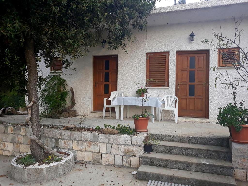 a table and chairs in front of a house at Apartments by the sea Cove Blaca, Mljet - 10416 in Maranovići