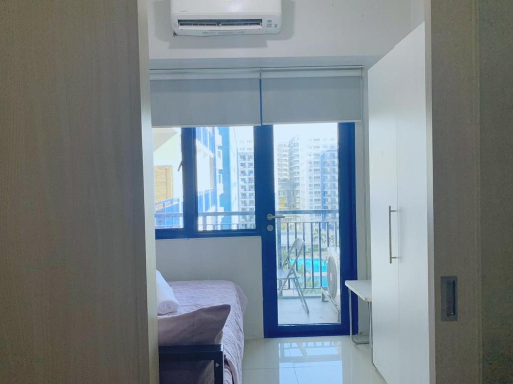 a bedroom with a bed and a window with a balcony at Sea Residences - Property Val Alano 0995-448-8872 in Manila
